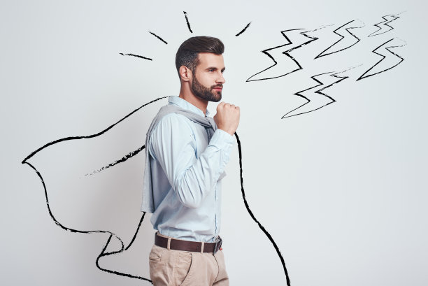 我足够坚强!自信和有吸引力的年轻人穿着一个绘制的斗篷显示姿态的成功，而站在灰色背景与插图的闪电图片下载