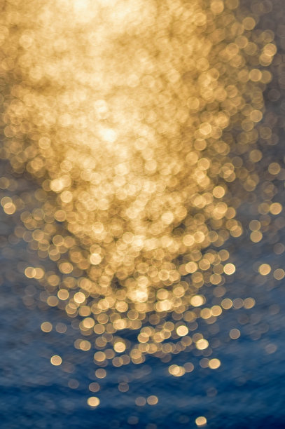 夕阳下的水景。夏季背景散焦照片。阳光散景闪烁着深蓝色的海水，地中海模糊的背景图片下载