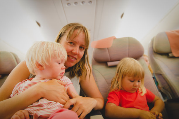 母亲带着孩子坐飞机旅行，全家都在飞机上图片下载