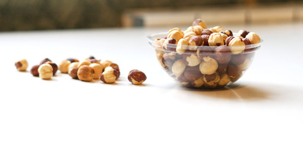 健康的食物背景图片近距离榛子。坚果纹理在白色灰色的桌子上的杯子盘上的视图图片下载