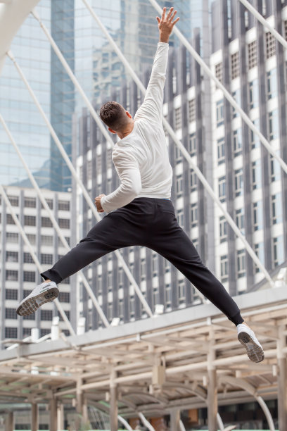 兴奋的健身者在城市里跳起来举手。运动，锻炼，后视镜图片下载