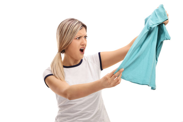 一个愤怒的女人拿着一件衣服看着它图片下载