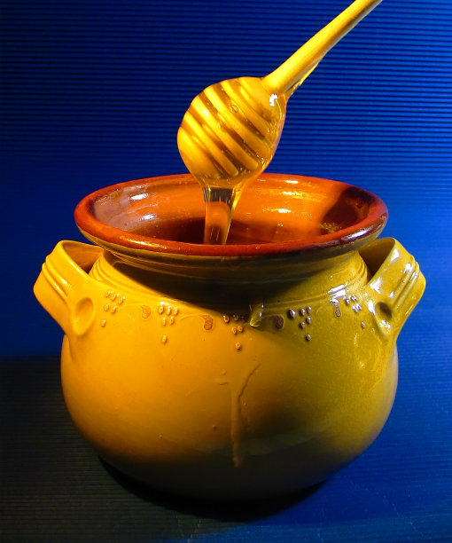 蜂蜜罐与勺和流动的蜂蜜图片下载