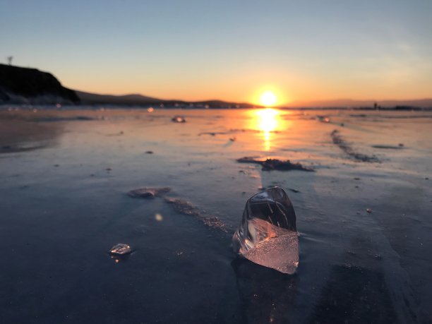 在夕阳的背景下，贝加尔湖上的冰冻冰块图片下载