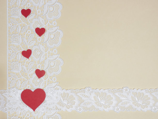 白色蕾丝在米色背景与红色的心图片下载