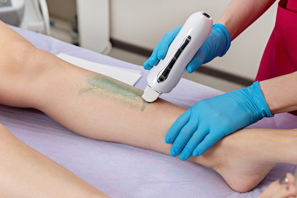 美容师在美容院给腿脱毛。美容和专业的身体护理。图片下载