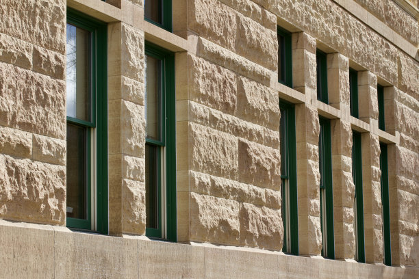 一个旧的米色kasota石灰石建筑墙壁和窗户的角度视图图片下载