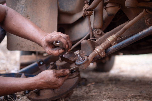 机械师的手固定卡车部件的横骨控制臂，以修复前轮图片下载