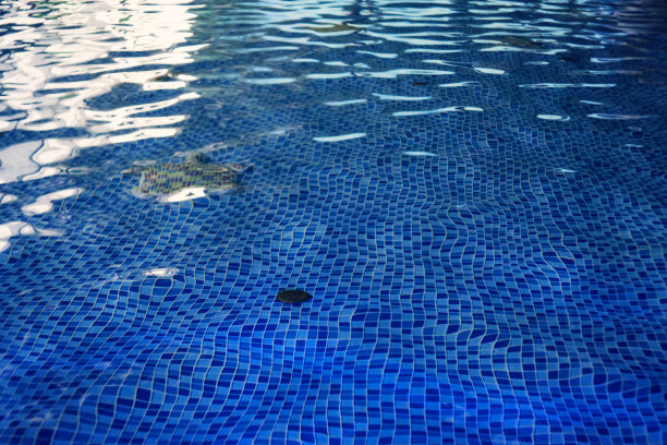 室内游泳池地板设计美观。水上公园水池的水下排水系统。蓝色瓷砖装饰的地面在水上公园的游泳池。洁净的水在室内的水池里荡漾图片下载