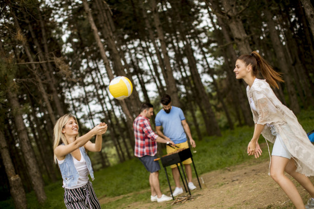 年轻女子在春天的野餐上打排球图片下载