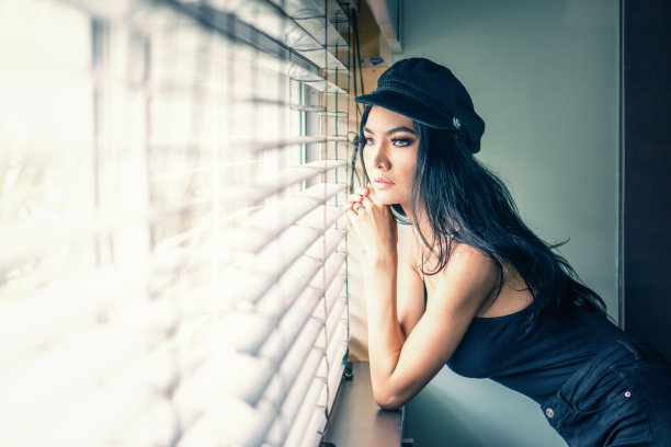 女性在窗边摆姿势的肖像图片下载