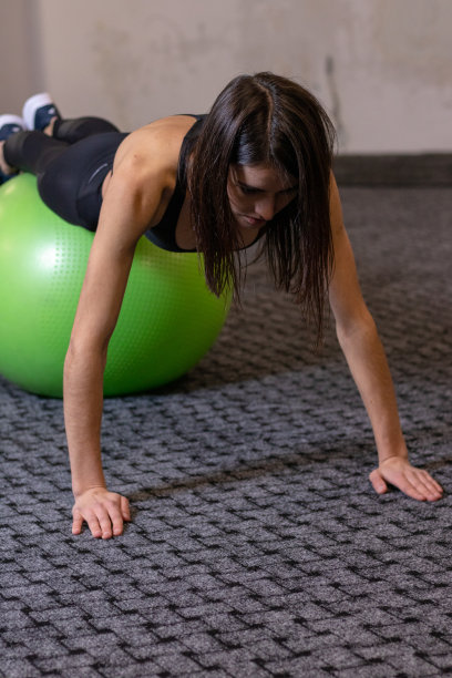 那个女孩正在健身房里练健身球图片下载