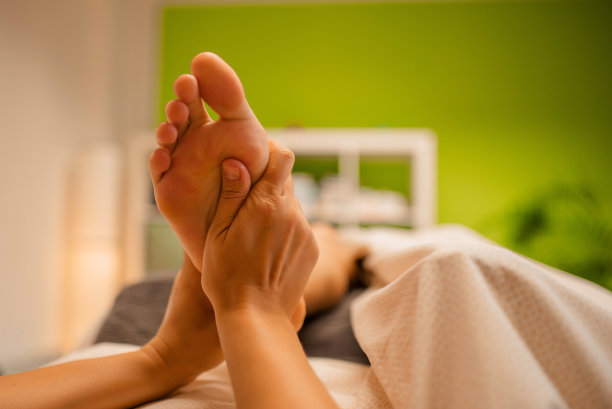 美丽的女人正在水疗美容沙龙放松脚部按摩。身体保健素材图片