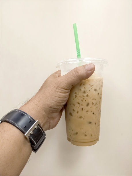 拿着一杯加牛奶的冰咖啡的男人图片下载