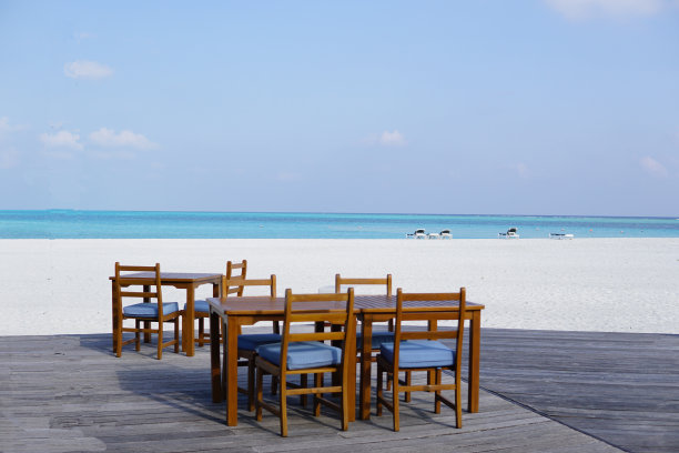 马尔代夫，白色沙滩和美丽天空附近的木地板餐桌图片下载