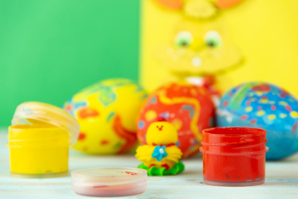 复活节彩蛋在多色木制背景与婴儿鸡，油漆和刷子图片下载