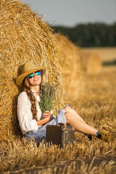 年轻女子在田里享受阳光图片下载