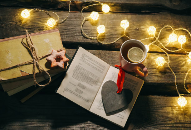 节日气氛的照片。圣诞彩灯和热茶杯。为舒适的夜晚订票。甜姜饼和木心放在托盘上。完美的冬季平躺。Hygge概念。图片下载