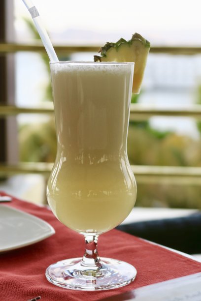 “Piña colada”酒精鸡尾酒/鸡尾酒饮料在节日的飓风杯与菠萝装饰和稻草，印度酒吧背景照片图片下载