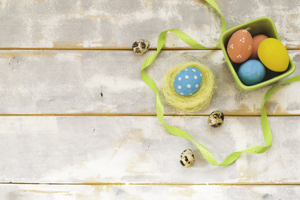 复活节背景与复活节彩蛋和丝带在木制的白色和灰色的桌子上。顶部视图与复制空间。图片下载