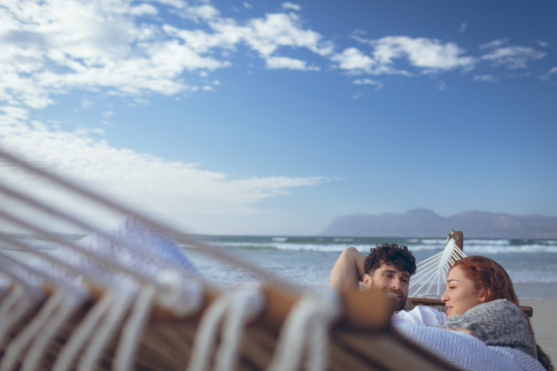 情侣在吊床上休息时互相互动图片下载