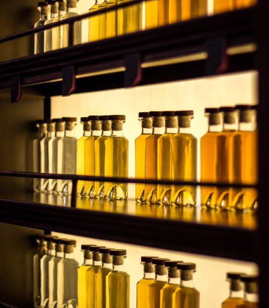 发光的木架子上放着装有黄色液体的玻璃瓶图片下载