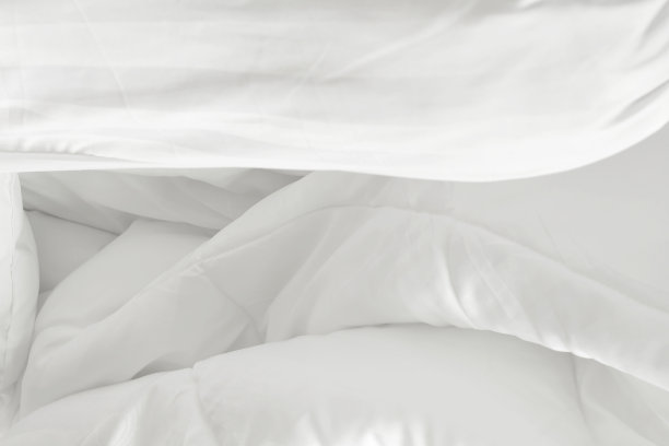 俯视图白色的枕头在床上和皱褶凌乱的毯子在卧室早上醒来后图片下载