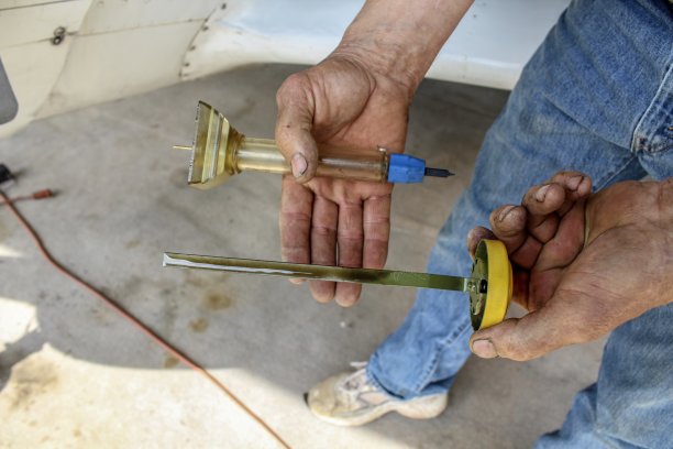 作为飞行前检查清单的一部分，手持油尺和盖特瓶的人图片下载