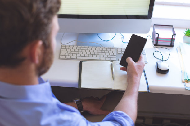 自信的男医生在诊所使用手机图片下载