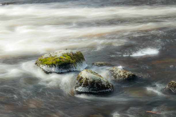长时间曝光的照片。芬兰库沃拉，粗糙的Jokelanjoki河和水中的石头。图片下载