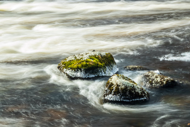 长时间曝光的照片。芬兰库沃拉，粗糙的Jokelanjoki河和水中的石头。图片下载