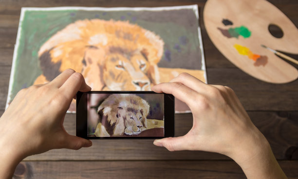 电话里有狮子的照片。在背景上画画，在手机上移动。图片下载
