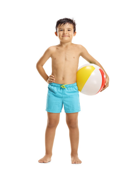 穿着游泳短裤的小男孩拿着沙滩球图片下载