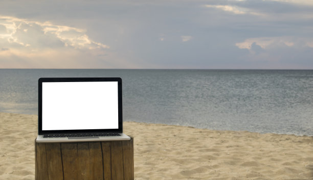在Blur夏日白沙滩上的桌子上放着黑屏笔记本电脑图片下载