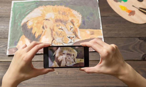 电话里有狮子的照片。在背景上画画，在手机上移动。图片下载
