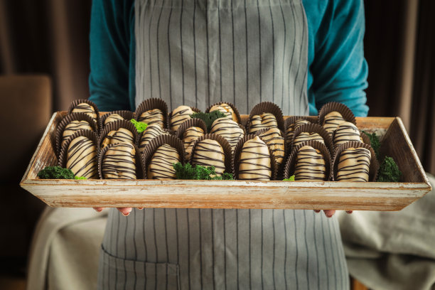 厨师拿着盛着美味小甜饼的木托盘图片下载