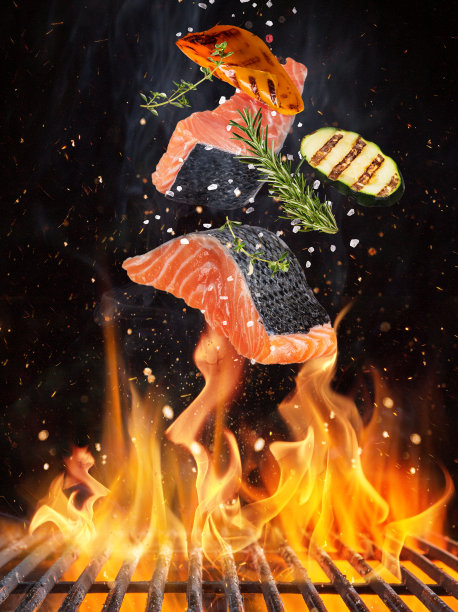 美味的鲑鱼排在燃烧的火焰中飞过。图片下载