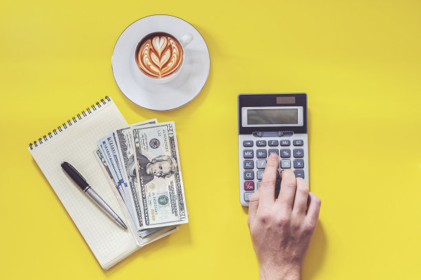 商业金钱和计算器概念上的黄色背景。拿的钱图片下载