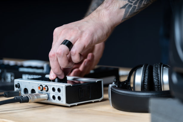 近和裁剪，侧视图照片纹身手的专业DJ男人。他制作音乐室内房间工作室与黑色的黑暗墙内部图片下载