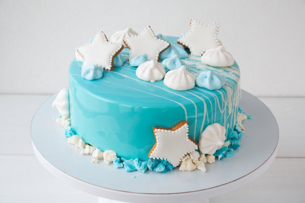 蛋糕以海洋、海洋为主题，装饰以蓝色镜面釉、星星、蛋白酥皮为白色背景。图片下载