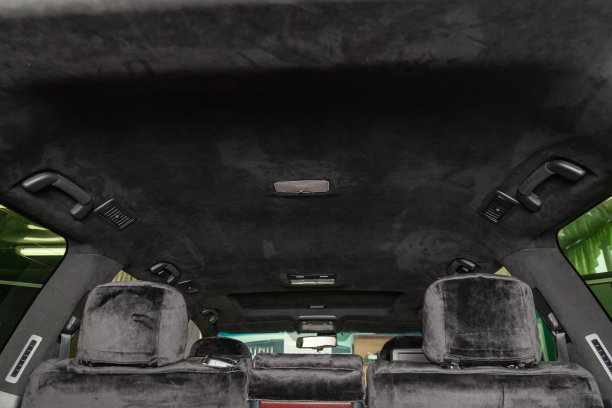 车间里的SUV车顶由黑色软质材料alkantara拉起，用于对带有天窗的车辆内部进行调整和造型。汽车服务行业。图片下载