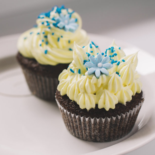 黄色的巧克力蛋糕，点缀着蓝色的花朵和糖屑图片下载