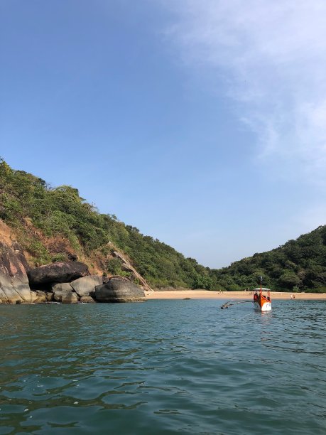 在印度果阿的Palolem蝴蝶海滩的图片，渔船/海豚游轮到达，热带植物，岩石和棕榈树的照片，柔软的金色沙子，温暖的海和附近的蜜月海滩图片下载
