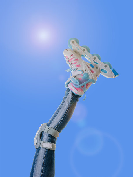 穿着旱冰鞋的孩子的右腿对着天空发出耀眼的光芒。图片下载