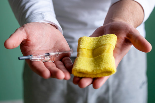 这个人手里拿着药和一个腕带。在运动中使用兴奋剂的概念。图片下载