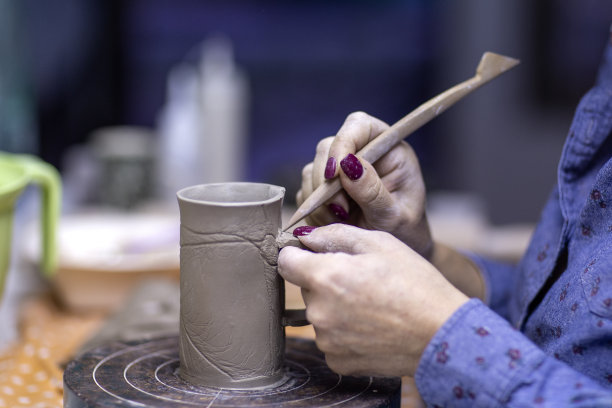 在工作室里用陶土制作马克杯的艺术家之手图片下载