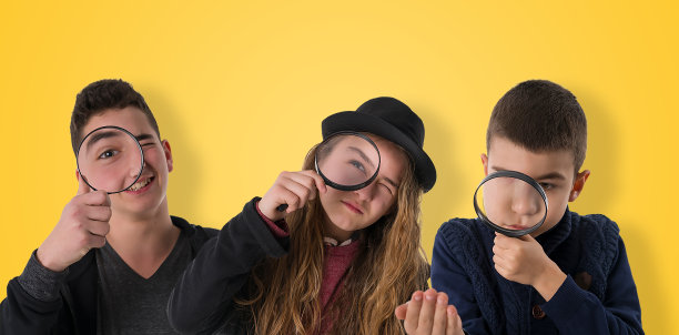 肖像快乐的孩子使用放大镜，彩色背景。图片下载