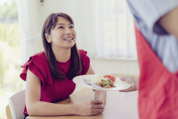 亚洲服务员微笑着为情侣们上菜。图片下载
