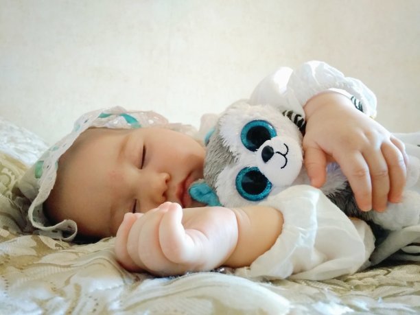 漂亮的小婴儿睡在米色的床上图片下载