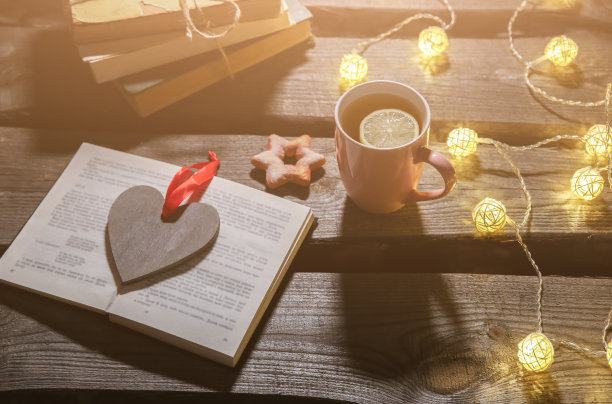 节日气氛的照片。圣诞彩灯和热茶杯。为舒适的夜晚订票。甜姜饼和木心放在托盘上。完美的冬季平躺。Hygge概念。图片下载